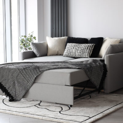 Small gray sofa with sleeping function when unfolded.